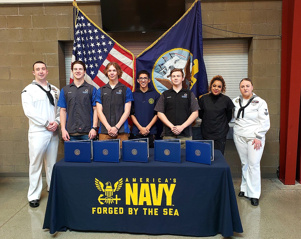 From left, Petty Officer Travis Goff celebrates with KTEC students and future sailors Daniel Schlothauer, Berg Zednik, Ryan Mondine, Connor Farkas, and Kendell Bentley, with their recruiter Petty Officer Meghan Wadsworth as they signed commitments to join the Navy.