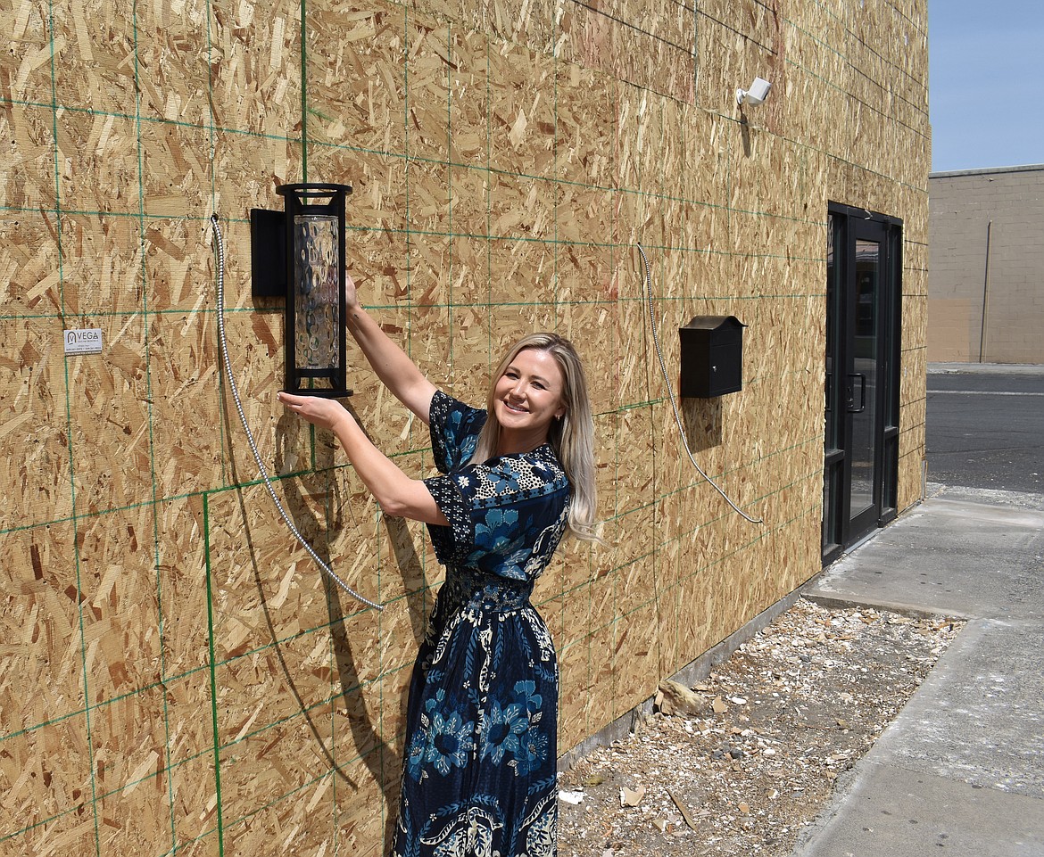 Anna Van Diest shows one of the lights that will grace the front of the building formerly known as Broadway Bar & Grill, but which is being renovated to house offices and a small brewery.