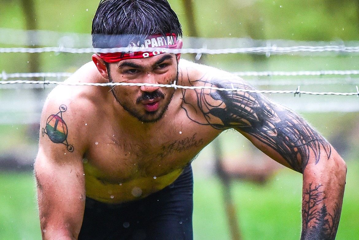 Gil Parent, from Milbank, South Dakota, navigates through the barbed wire crawl obstacle at the Montana Spartan Trifecta in Bigfork on Saturday, May 6. (Casey Kreider/Daily Inter Lake)
