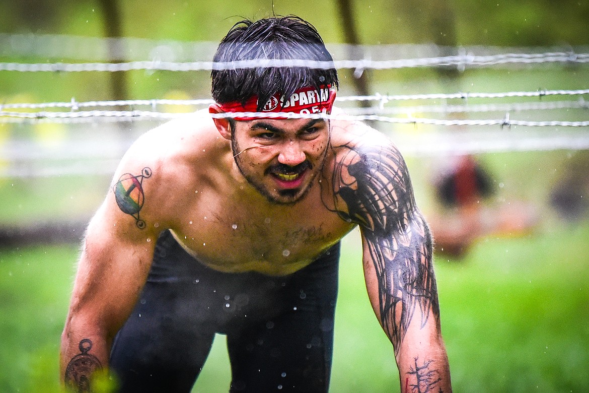 Gil Parent, from Milbank, South Dakota, navigates through the barbed wire crawl obstacle at the Montana Spartan Trifecta in Bigfork on Saturday, May 6. (Casey Kreider/Daily Inter Lake)