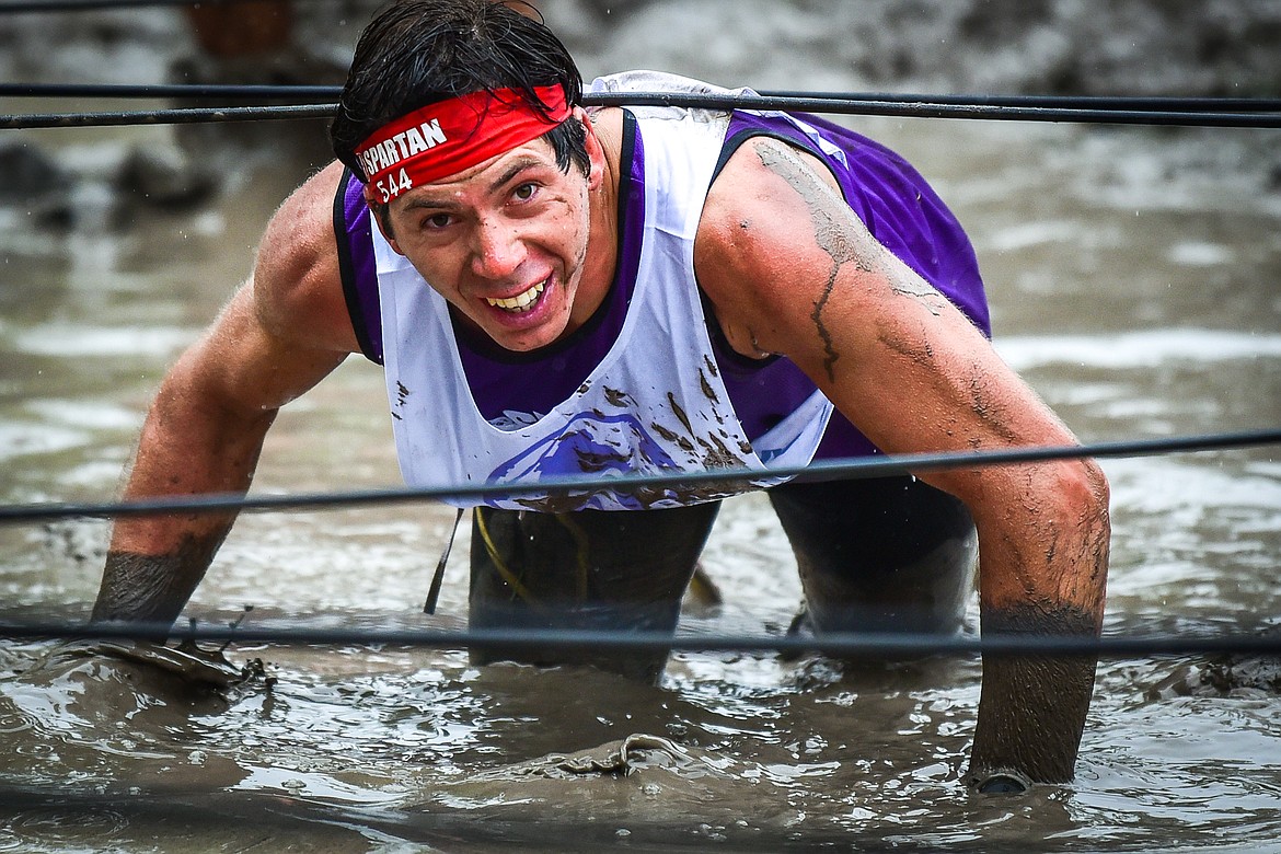 Elmer King, of Bird-In-Hand, Pennsylvania, who placed first in the Ultra 50K race, crawls through a water obstacle at the Montana Spartan Trifecta in Bigfork on Saturday, May 6. (Casey Kreider/Daily Inter Lake)