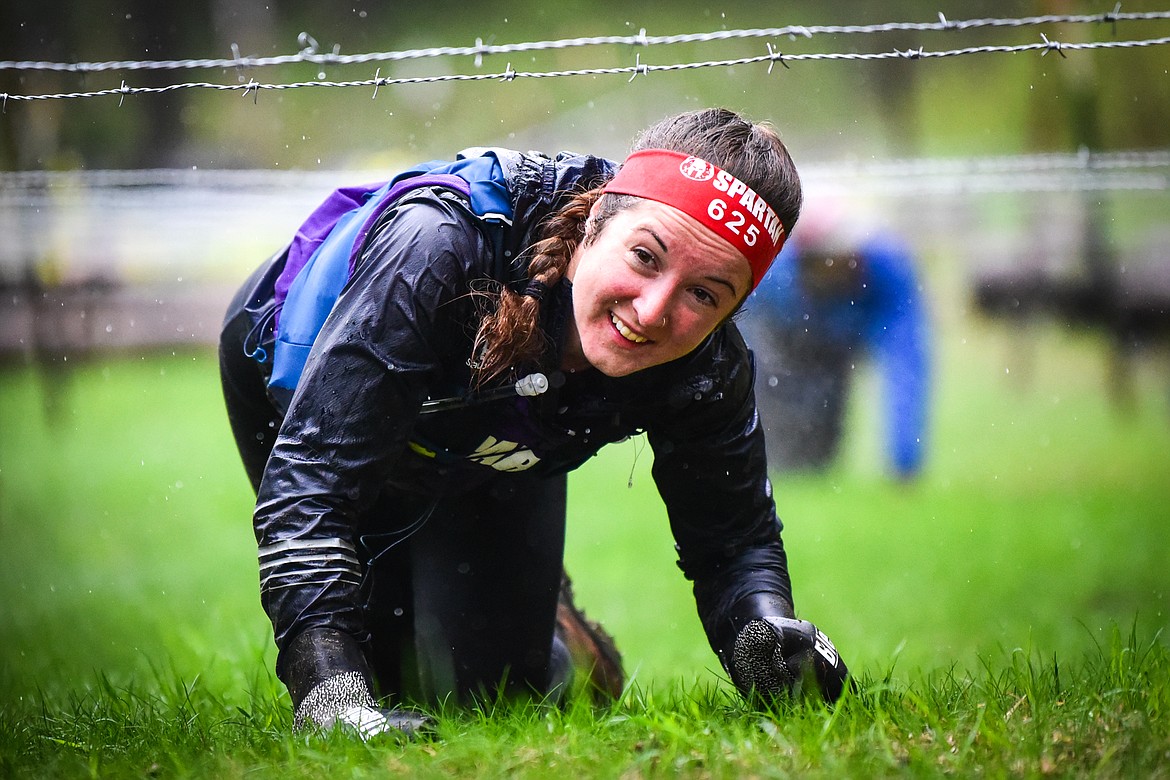 Stephanie Graham, of Spruce Grove, Alberta, Canada, who finished first in the female Ultra 50K race, navigates through the barbed wire crawl obstacle at the Montana Spartan Trifecta in Bigfork on Saturday, May 6. (Casey Kreider/Daily Inter Lake)
