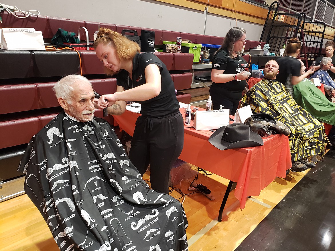 Volunteer Brienna Barron with Sport Clips gives Dan Cooley a haircut at the North Idaho Veterans Stand Down. Around 60 vendors came to North Idaho College to provide resources to roughly 400 veterans Saturday.