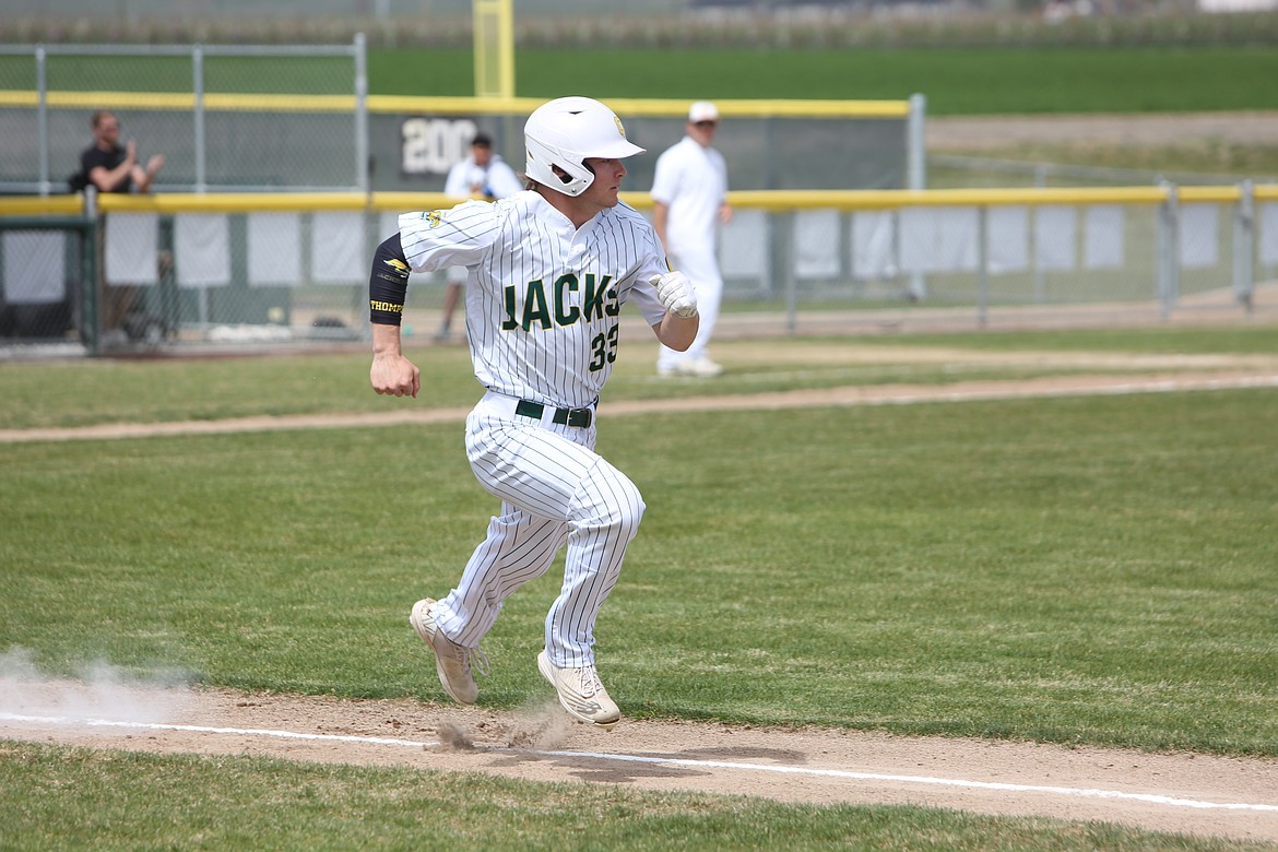 Quincy senior Kenny Thompson sprints toward first base after hitting a ground ball in the infield.