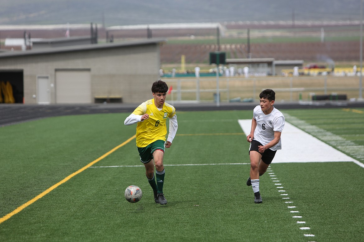 Quincy senior Alexandro Hernandez looks for an open teammate against Royal on April 15.