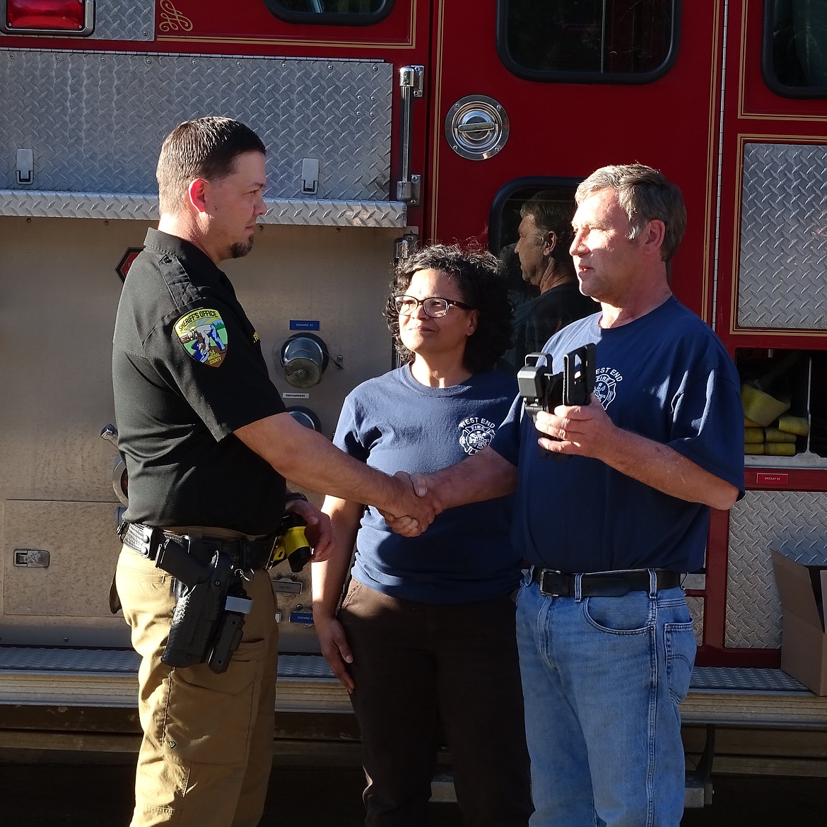 Mineral County Sheriff Ryan Funke is presented with Rapid Force Duty Holsters from by Frank Magee, fire chief of the West End Volunteer Fire Department in DeBorgia recently. The West End Fire and Rescue volunteers gathered donations for the purchase following a stand-off in St. Regis in March. Magee said the occasion was for first responders supporting other first responders. (Monte Turner/Mineral Independent)