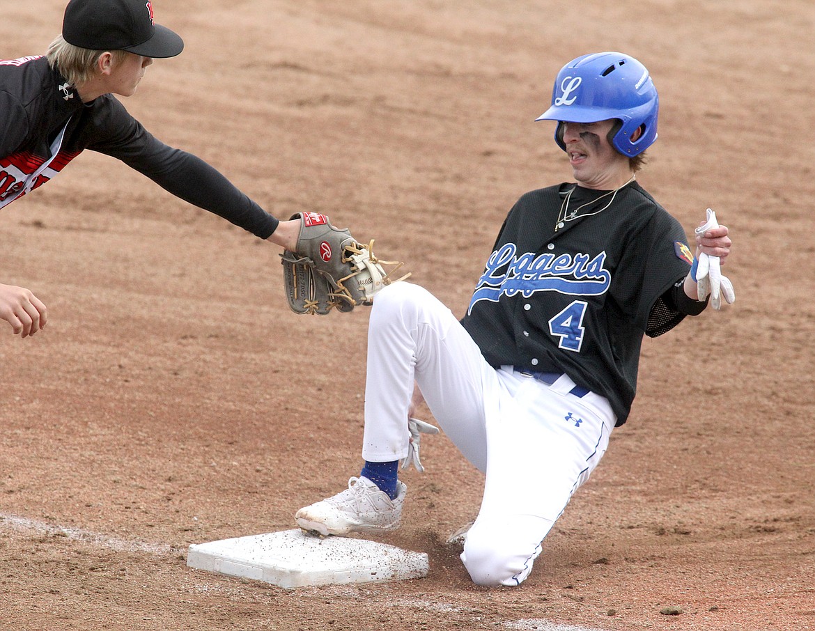Libby Logger Dylan Buckner slides safely under the tag of Kalispell third baseman Miles Arrowsmith in the bottom of the first inning Sunday during the Loggertown Wood Bat Classic 2023. (Paul Sievers/The Western News)