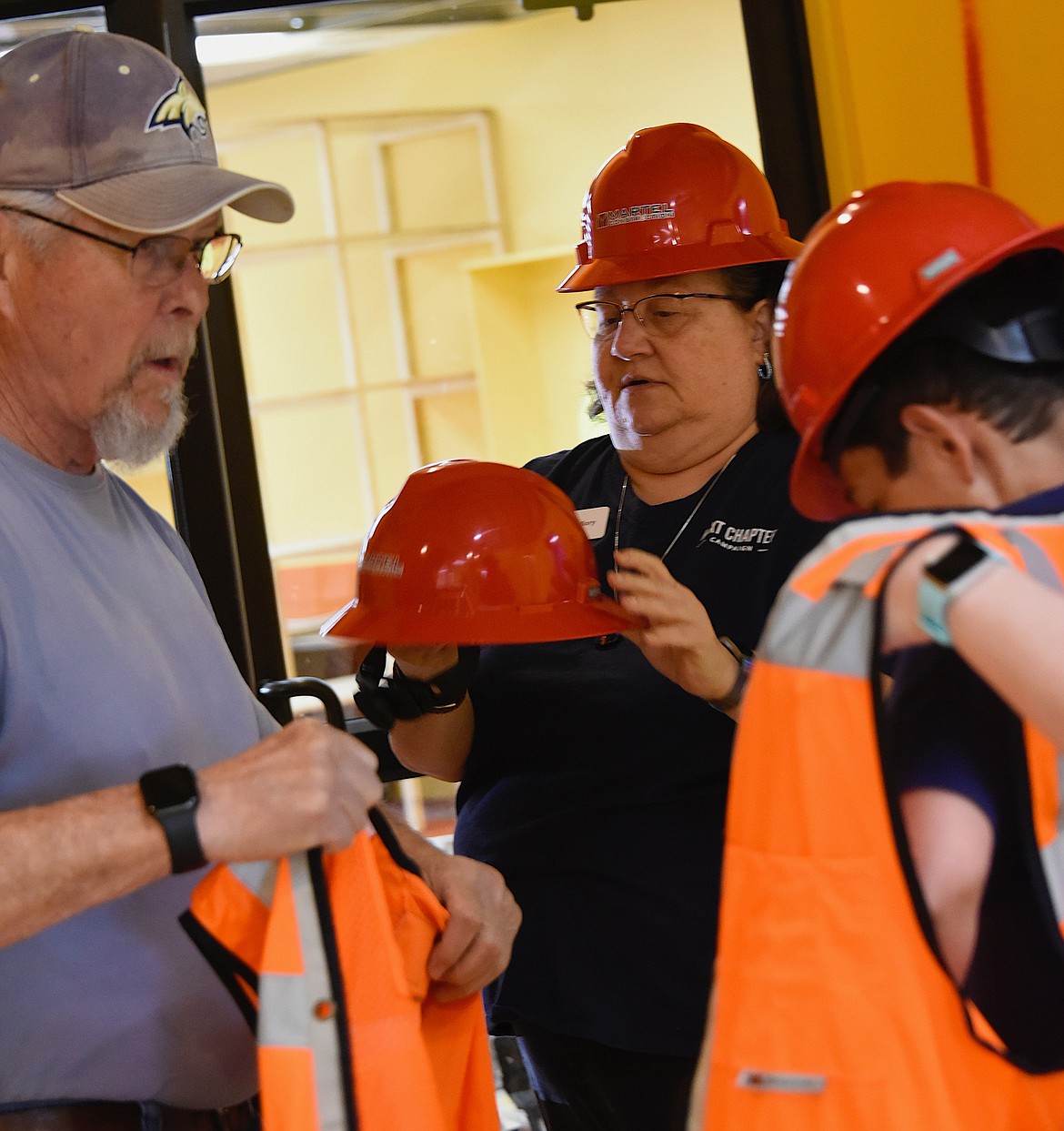 North Lake County Library District Board Member Allen Bone, left, and employees Mallory Witham and Maclain Burningham suit up for demolition day at the library. (Berl Tiskus/Leader)