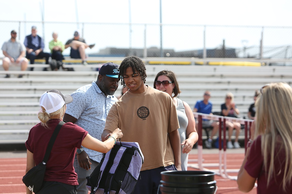 Moses Lake senior Amari Patterson walks across the track during the team’s senior night ceremony. Seniors received a backpack as well as flowers during Thursday’s ceremony honoring the soon-to-be-graduating athletes.