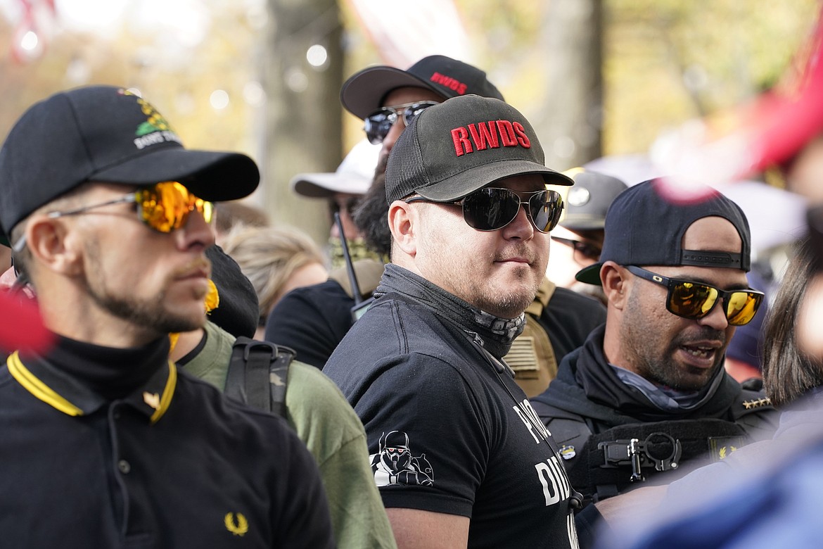 FILE - People identifying themselves as members of the Proud Boys join supporters of President Donald Trump for pro-Trump marches, Nov. 14, 2020, in Washington. Two supporter in the center are wearing hats with red lettering that read “RWDS,” which is short for “Right Wing Death Squad.” The gunman who killed eight people on Saturday, May 6, 2023, at a Dallas-area mall was wearing a “RWDS” patch. The phrase has been embraced in recent years by far-right extremists who glorify violence against their political enemies. (AP Photo/Jacquelyn Martin, File)