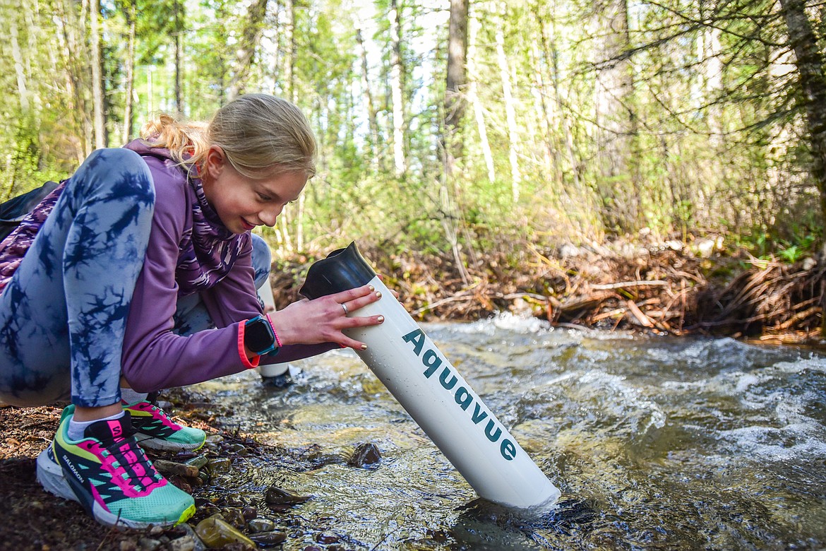 Greta Wells, a fifth-grader in Gabe Buzzell's class at Edgerton Elementary School, inspects the bottom of Trumbull Creek with a viewing tube at the fisheries station of the Family Forestry Expo at Trumbull Creek Educational Forest in Columbia Falls on Tuesday, May 9. (Casey Kreider/Daily Inter Lake)