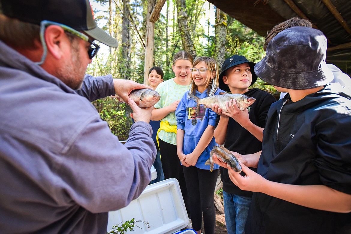 Fifth-graders in teacher Gabe Buzzell's class at Edgerton Elementary School listen to a presentation on different types of fish found in local waterways by Montana FWP fisheries biologist Leo Rosenthal at the Family Forestry Expo at Trumbull Creek Educational Forest in Columbia Falls on Tuesday, May 9. (Casey Kreider/Daily Inter Lake)