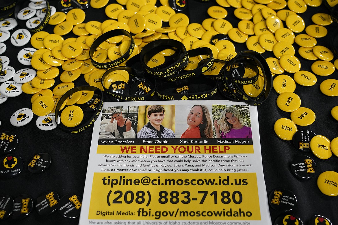 A flyer seeking information about the killings of four University of Idaho students who were found dead is displayed on a table along with buttons and bracelets on Nov. 30, 2022, during a vigil in memory of the victims in Moscow, Idaho. A media coalition is trying again to get a gag order lifted in the criminal case of Kohberger, accused of fatally stabbing the students. (AP Photo/Ted S. Warren, File)