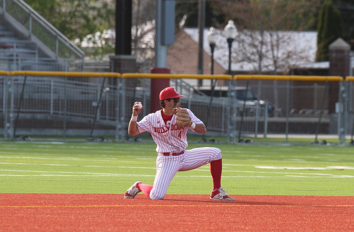 Drew Lehman makes a throw from his knees to first base for an out in the top of the first inning.