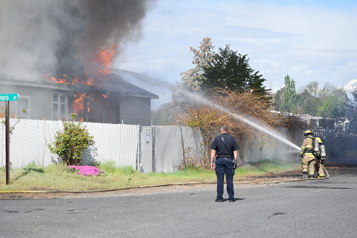 Firefighters with Grant County Fire District 5 battle a blaze Tuesday morning at the corner of Chera Place and Broad Street NE not far from the S.R. 17 and Grape Drive roundabout.