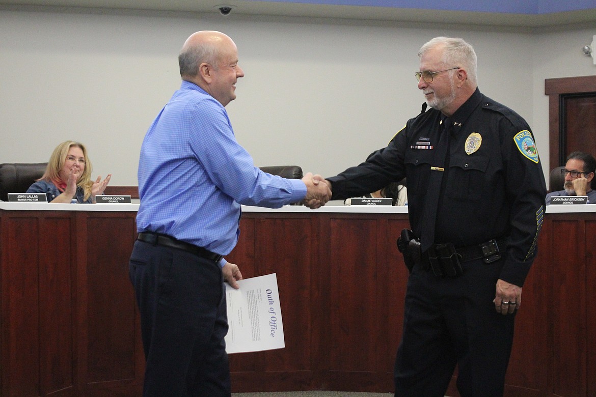 Assistant Othello Police Chief Dave Rehaume, right, shakes hands with Othello Mayor Shawn Logan, left, after Rehaume was sworn in as interim chief.