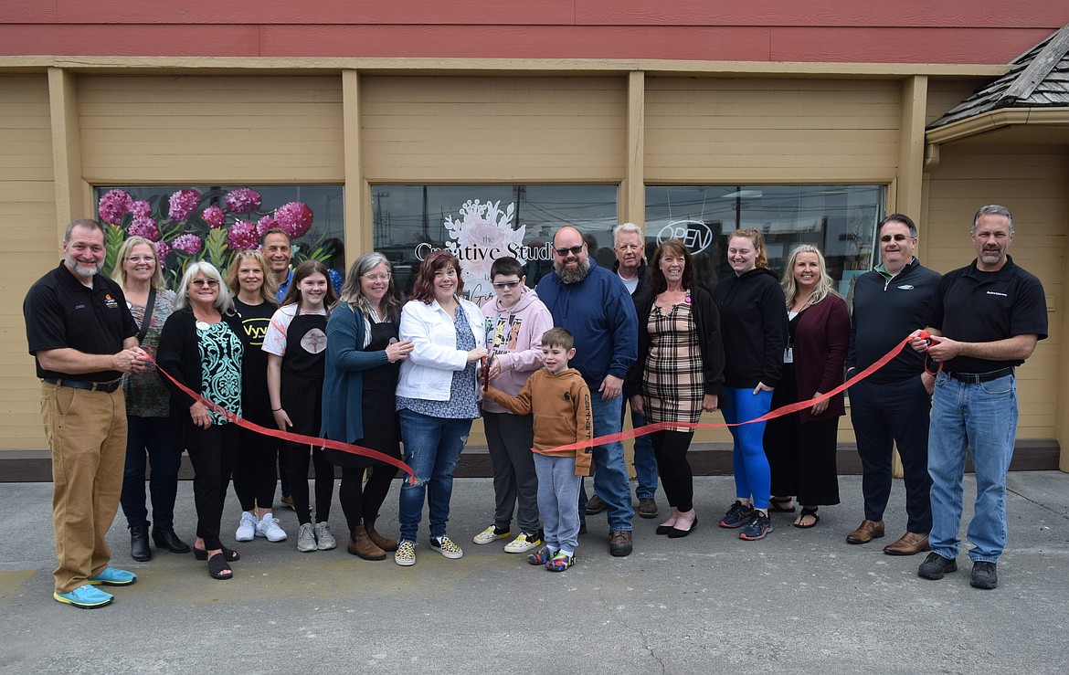 Krista Courier, surrounded by family and members of the Moses Lake Chamber of Commerce, cuts the ribbon last week on her new business The Creative Studio by Rustic Girl Painting at 1001 W. Broadway Ave. in Moses Lake.