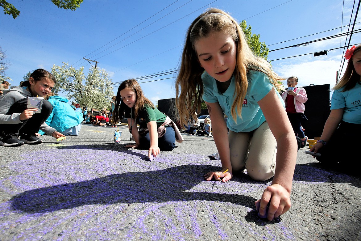 Sorensen Magnet School of the Arts and Humanities third graders, from left, Malia Love, Cali Cross and Birdie Bailey create art for the 5th Street Farmers Market on Tuesday in downtown Coeur d'Alene.