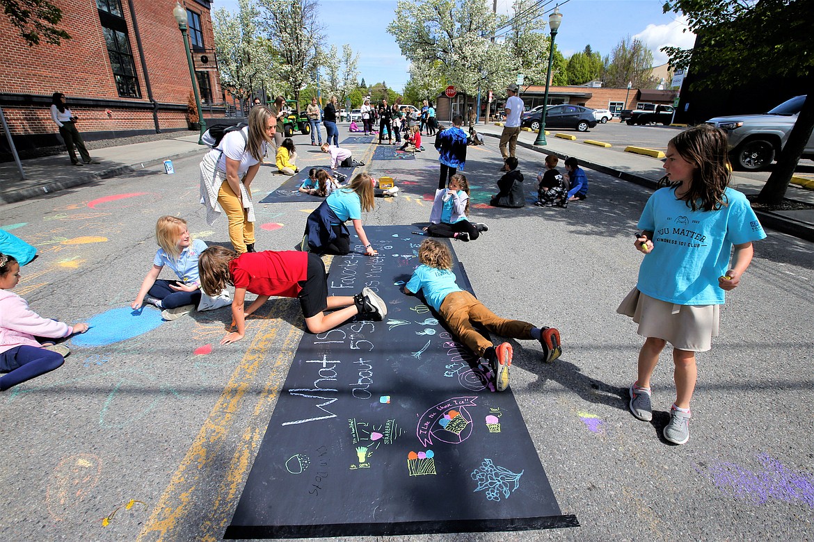 Sorensen Magnet School of the Arts and Humanities third graders create art and work on a poster for the 5th Street Farmers Market on Tuesday in downtown Coeur d'Alene.