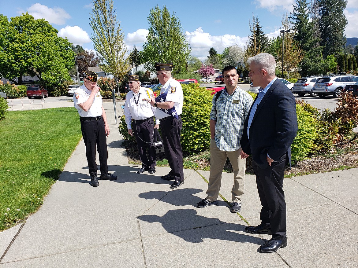 From left, Veterans of Foreign War Post 889 members Bob Martin, Lew Allert and Jeff Broadhead discuss a flag retirement ceremony at Venture High School in Coeur d'Alene with photographer Trevor Miller and Kootenai County Commissioner Bruce Mattare preparing for the ceremony to start.