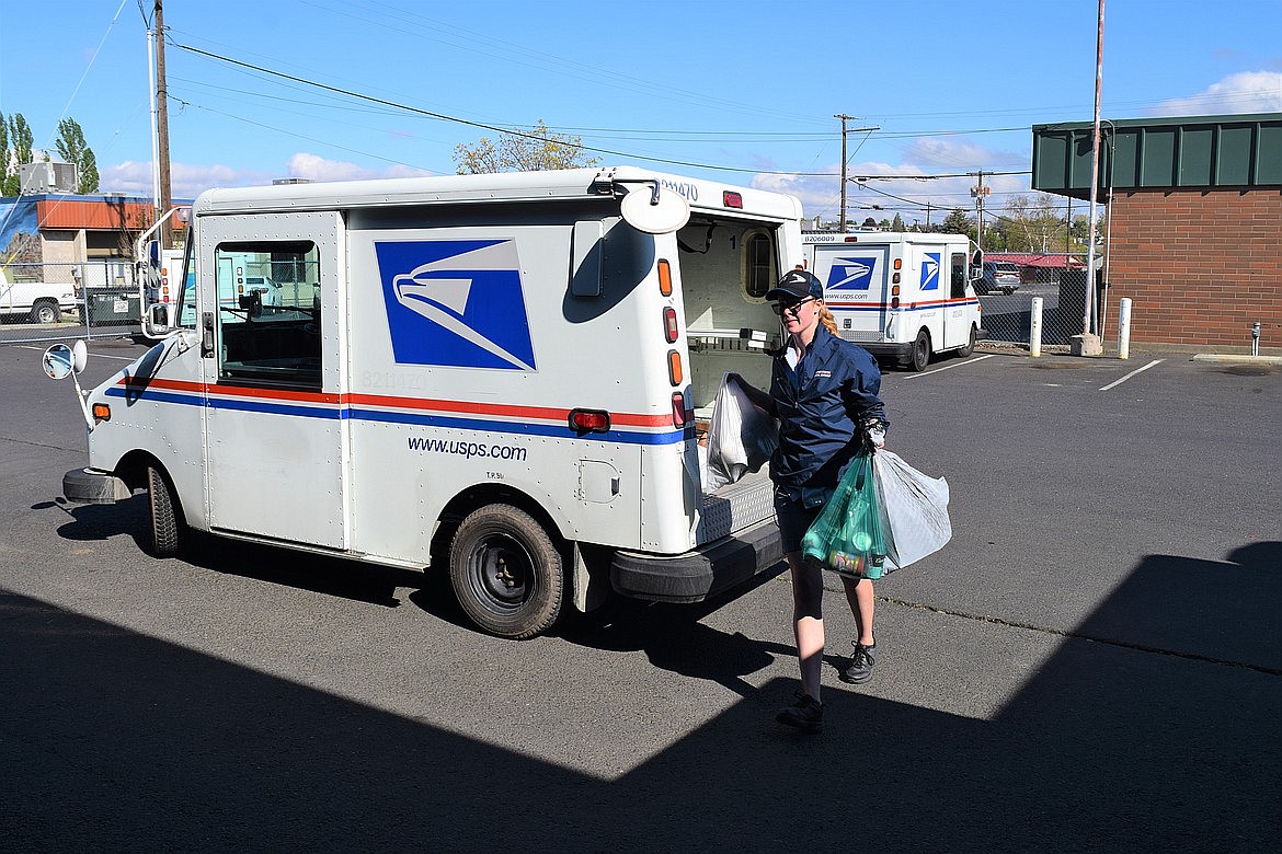 Letter Carrier Melanie Spaeth brings in several bags of canned goods from her route during last year's Stamp Out Hunger event.