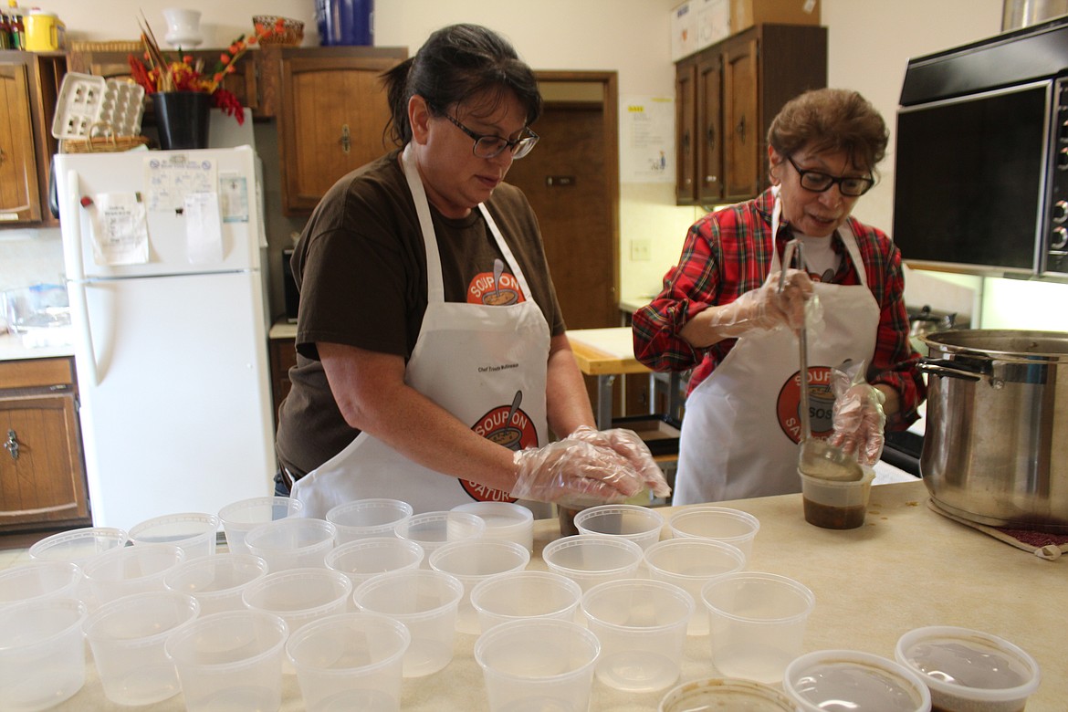 Trinette Mullineaux, left, and her mom Lydia Mullineaux, right, dish soup into the individual containers that will be taken to the Open Doors Sleep Center.