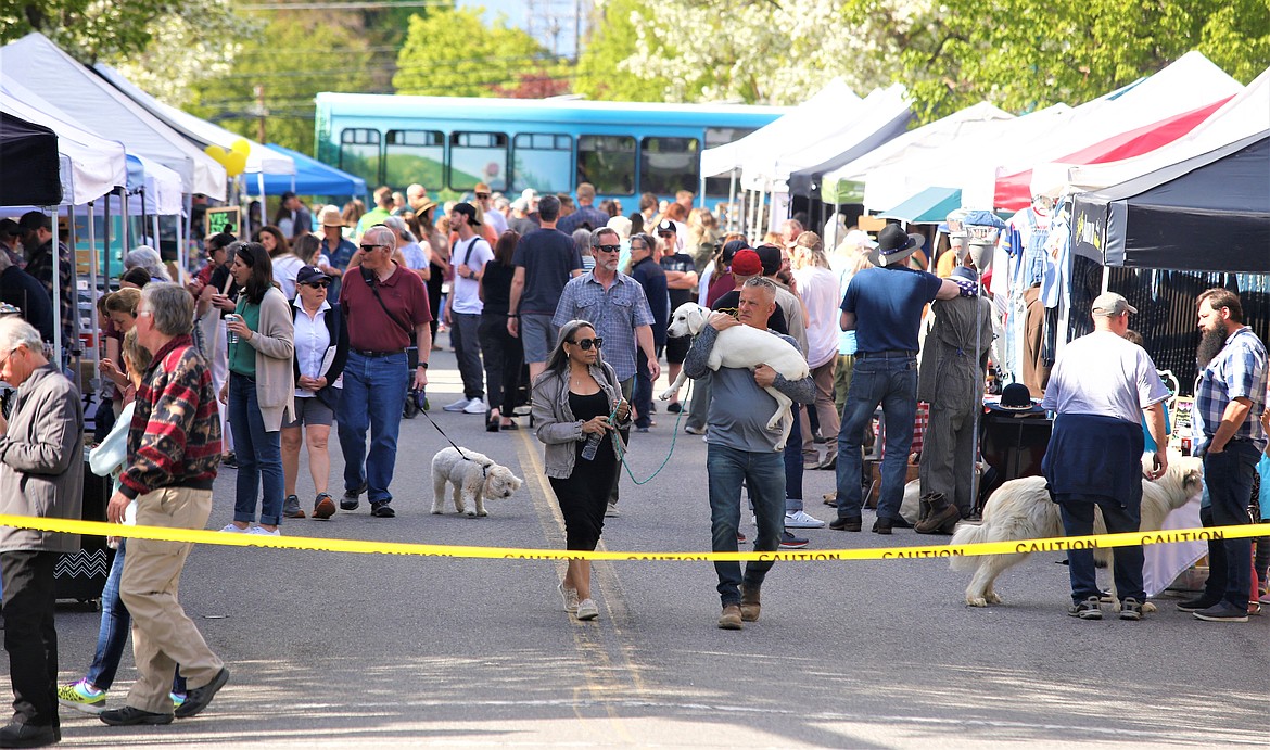 People and pets wander through the 5th Street Farmers Market on Wednesday.