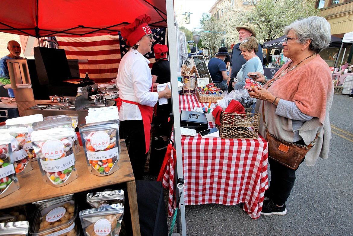 Karen Markarian of PJ's Dawgs visits with Elizabeth Brandt on opening day of the 5th Street Farmers Market on Wednesday.