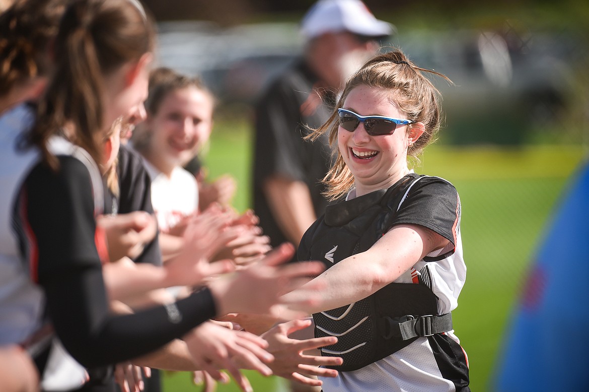 Flathead catcher Laynee Vessar (12) smiles as she slaps hands with teammates after her name is read during player introductions before the game with Missoula Hellgate on Thursday, May 11. (Casey Kreider/Daily Inter Lake)