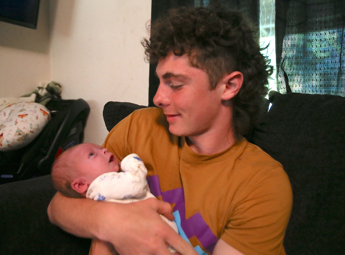 Baby Waylon Aurora looks up at his big brother Jacob Aurora, 14, Thursday at their Cataldo home.