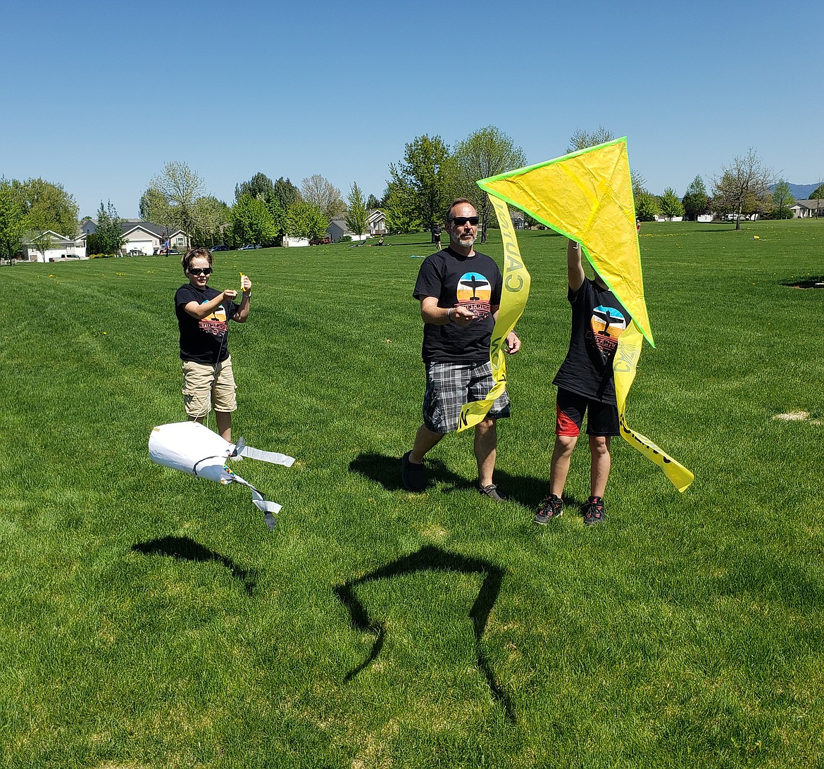 From left, Oscar, Kevin and Shepherd Ward launch their homemade kites, and "throw caution to the wind," Saturday at the Hayden kite festival.