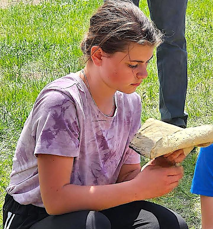 A student takes a close look at a piece of tanned buffalo hide at the River Honoring. (Berl Tiskus/Leader)