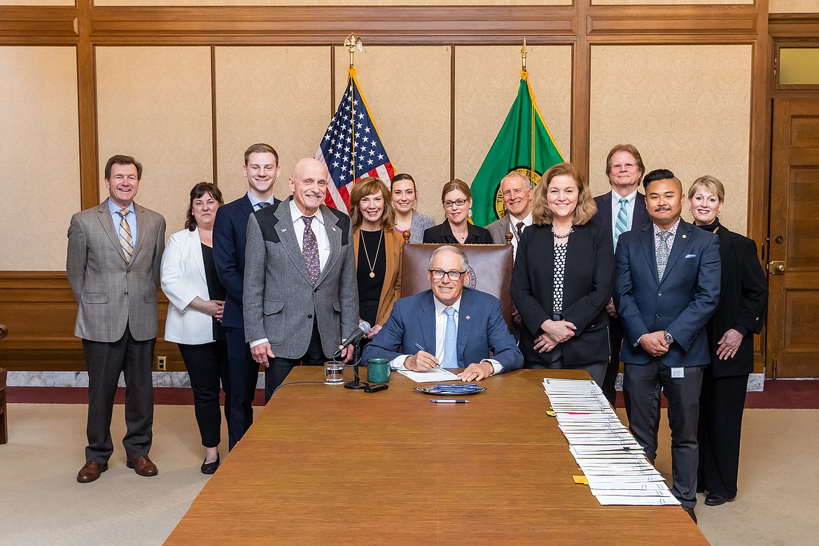 Tom Dent, left front, at the signing ceremony for HB 1032. The bill was signed into law by Washington Gov. Jay Inslee, center front.