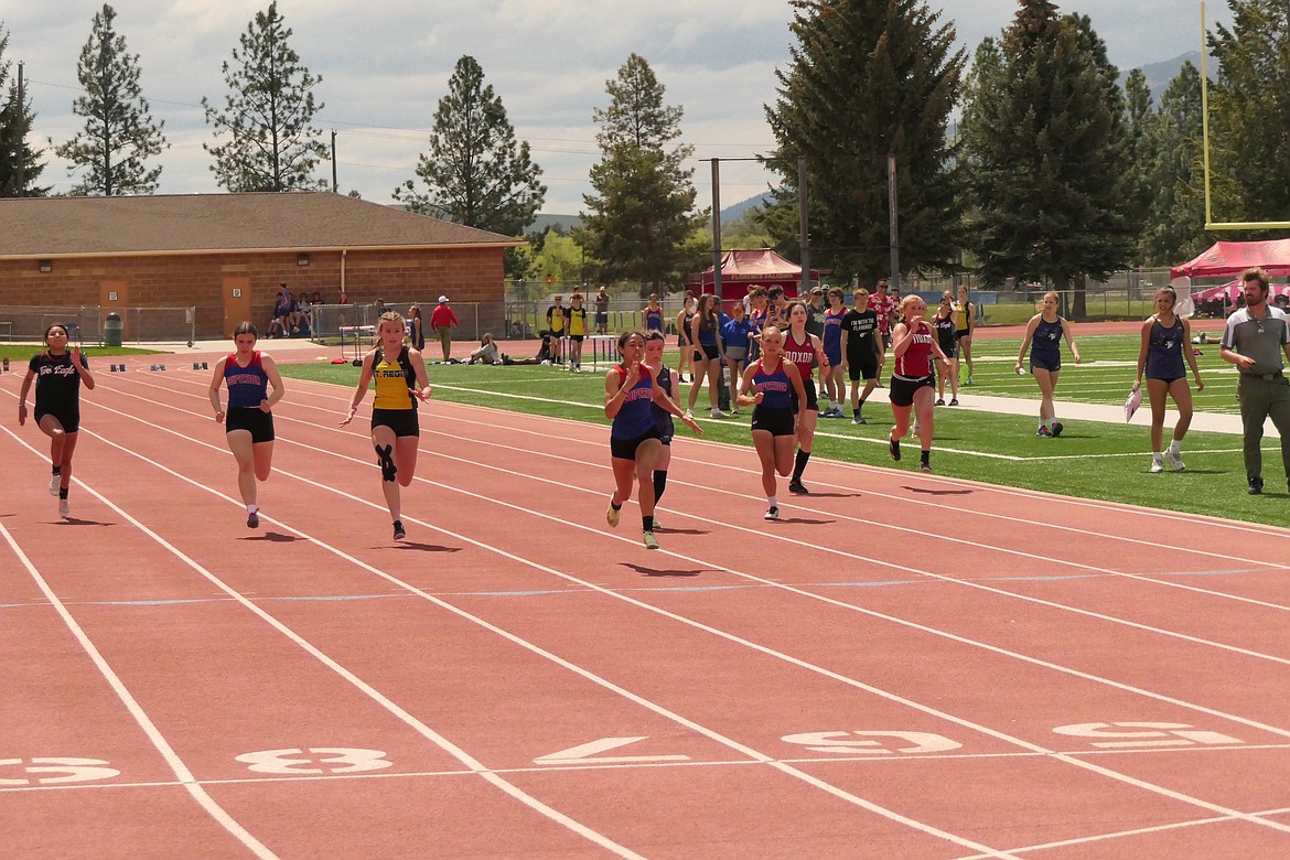 Superior senior sprinter Isabella Pereria leads the pack across the finish line on her way to winning the women's 100 meter sprint Saturday at the District 14C track and field Championships in Missoula.  St. Regis freshman Jamie Dearbey (yellow jersey) was second.  (Chuck Bandel/VP-MI)