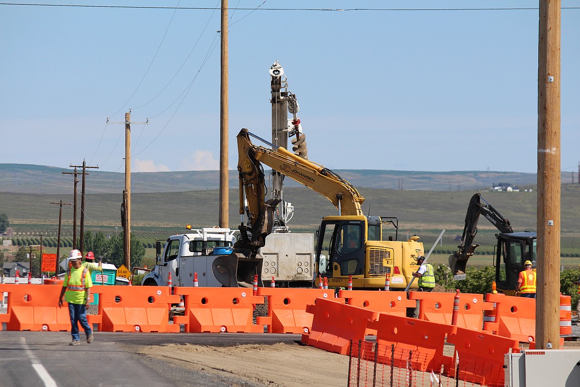 Construction workers install a concrete vault for fiber optic cables at the roundabout project at the intersection of State Route 28 and White Trail Road last week. Project completion will be delayed, although Washington Department of Transportation officials said they haven’t yet established a new completion date.