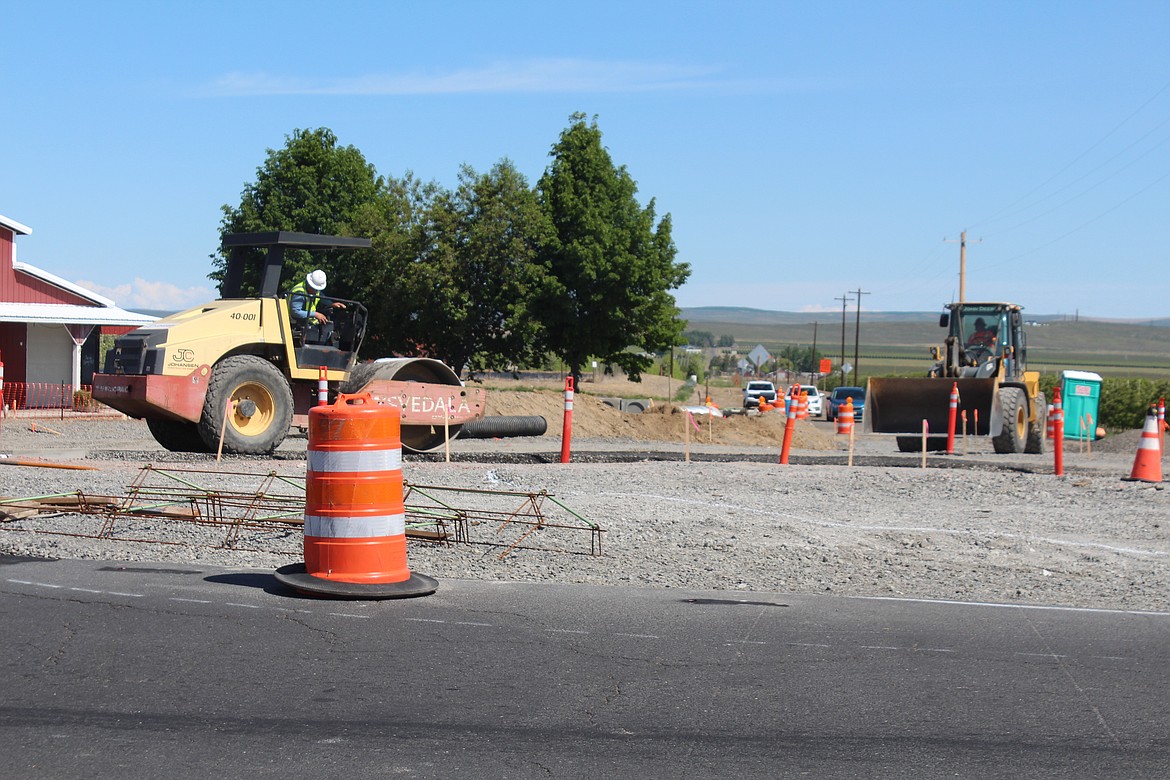 A worker compacts gravel at the roundabout under construction at the intersection of White Trail Road and State Route 28.