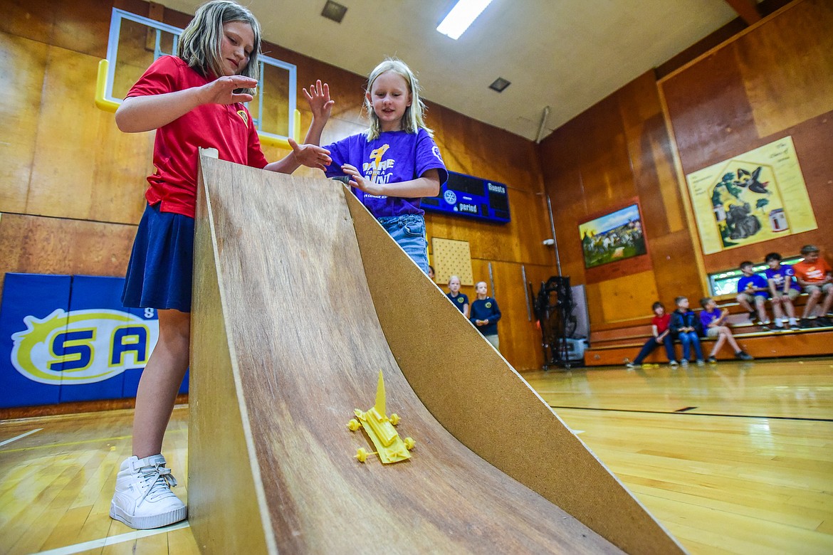 St. Matthew's School third-graders Amelia McCubbins and Addie Robbins release their pasta mobile, a vehicle constructed entirely of pasta and glue, down a ramp in hopes that it will stay intact as part of teacher Susie Rainwater's K-5 science class on Wednesday, May 17. (Casey Kreider/Daily Inter Lake)