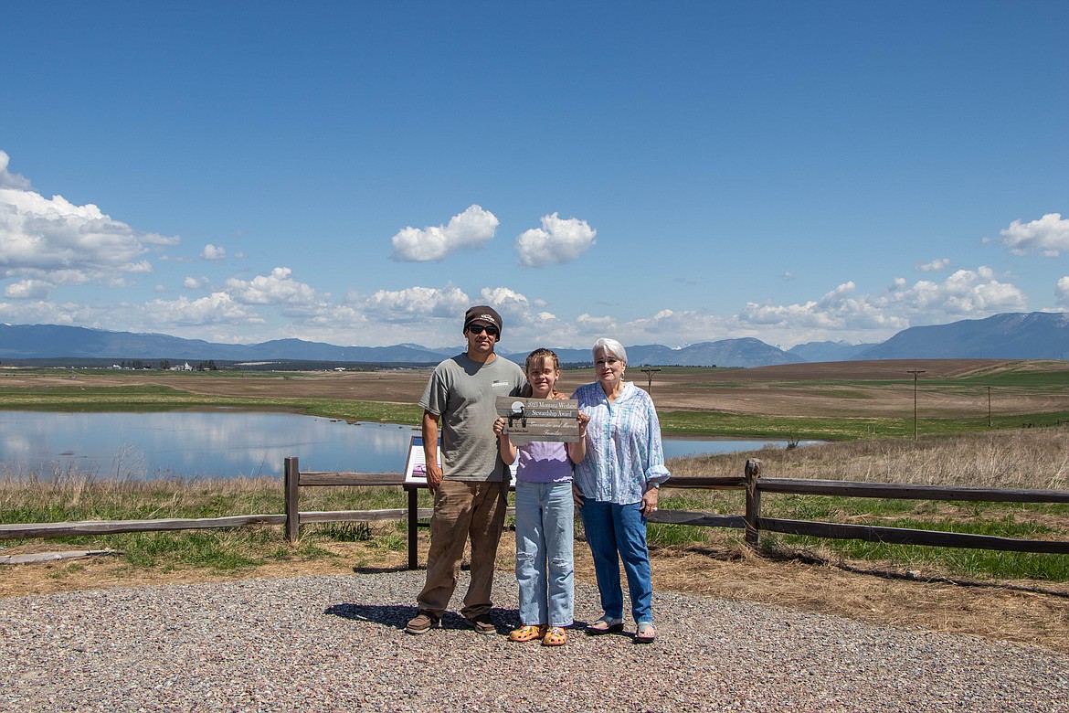 Tanner Marvin, Gracie Marvin, and Catherine Baier pose for a portrait, holding their 2023 Montana Watershed and Wetland Stewardship Award on their property. (Kate Heston/Daily Inter Lake)