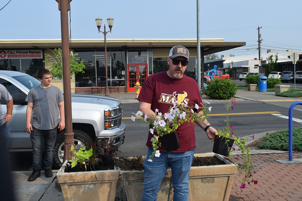 Moses Lake High School ag instructor Tony Kern gives his crew pointers on showing the plants to their best advantage.