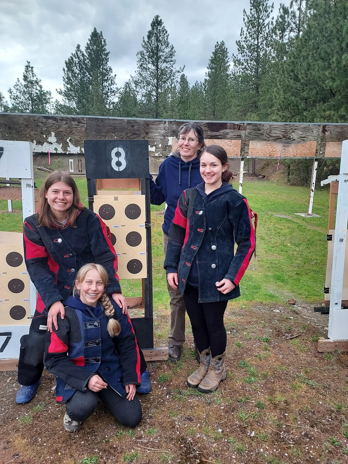 Members of the Kootenai Valley Rifle Club posed for a picture. Pictured is Kyalynn Comer's kneeling target at 50 meters. On the left are Salix Harris and Paige Sartell and, on the right side, are Kathy Konek and Kyalynn Comer.