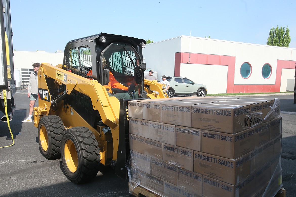 Mike Masters of Perfection Traffic Control helps move pallets of spaghetti sauce May 17 at Newby-ginnings of North Idaho in Post Falls.