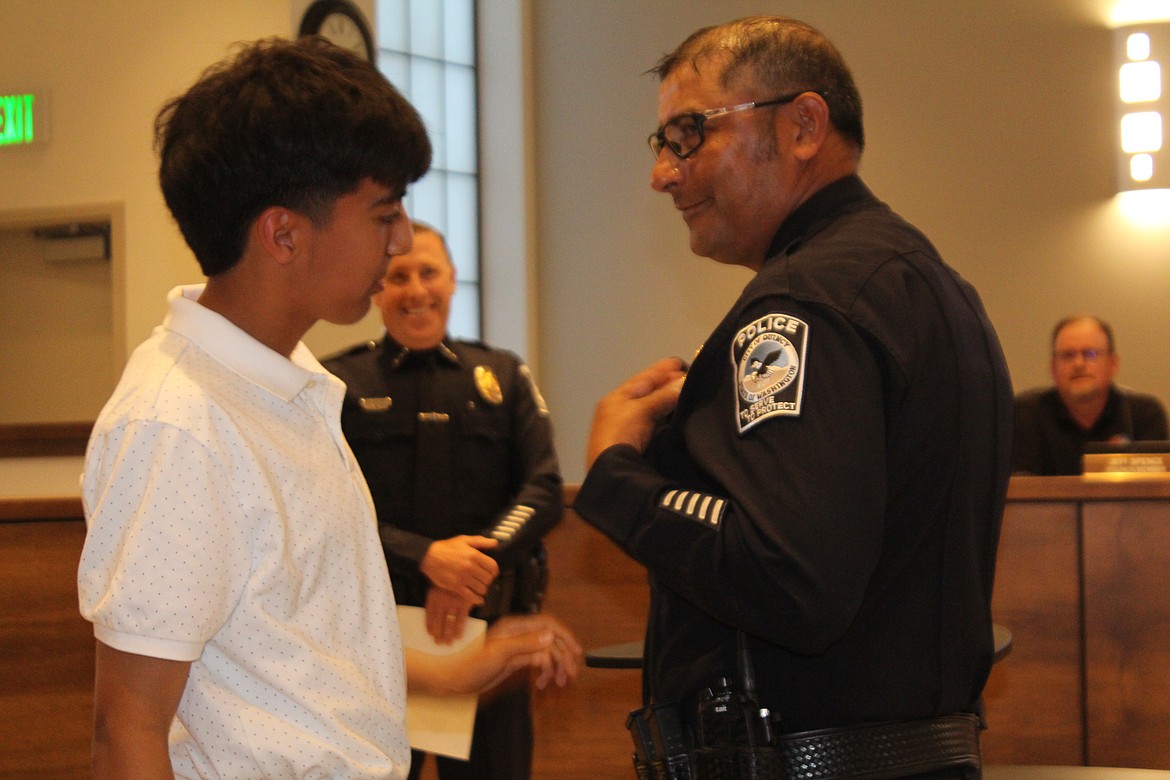 Jorge Trujillo’s son Alejandro, left, pinned on his dad’s new captain’s badge during the swearing-in ceremony for Trujillo, right.