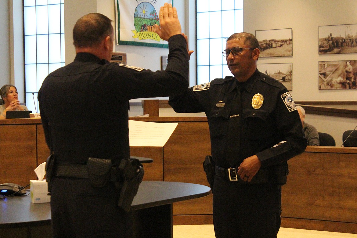 Jorge Trujillo, right, is sworn in as the new Quincy Police Department captain by QPD Chief Ryan Green, left.