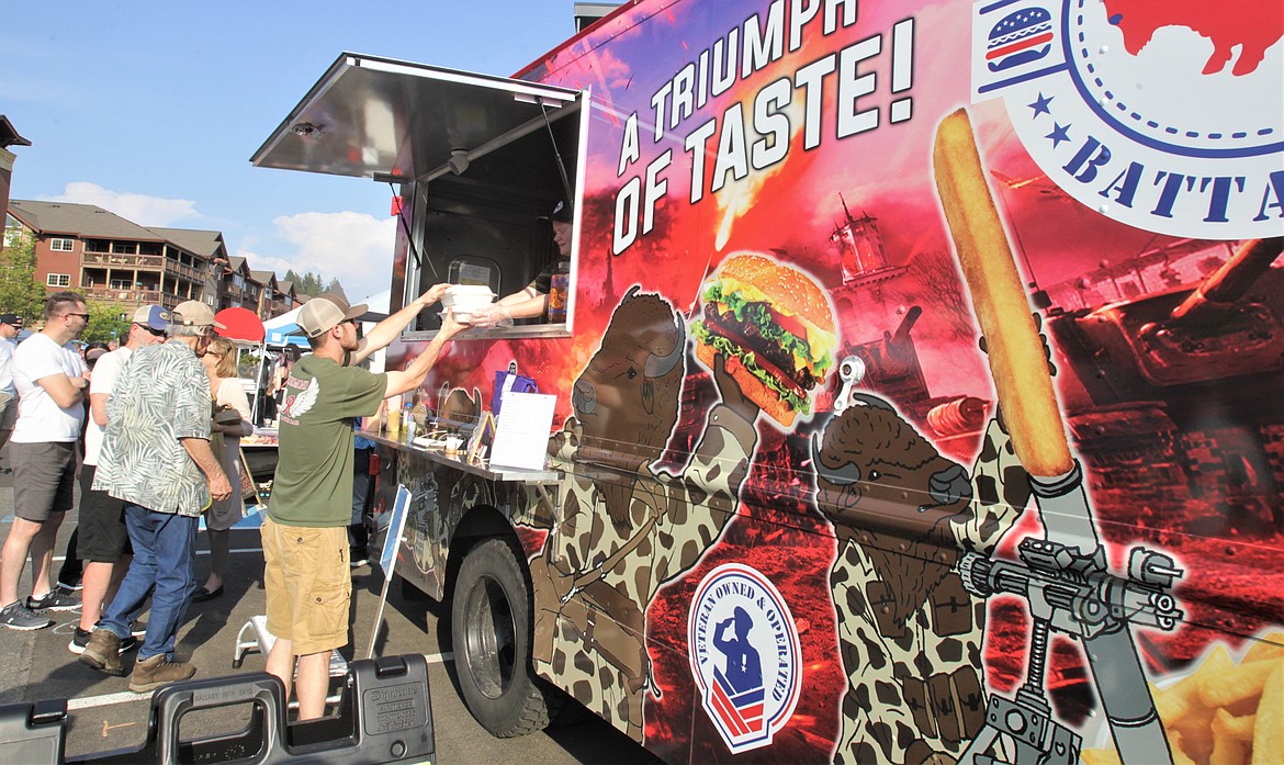 A customer receives a burger at the Kootenai County Farmers' Market.