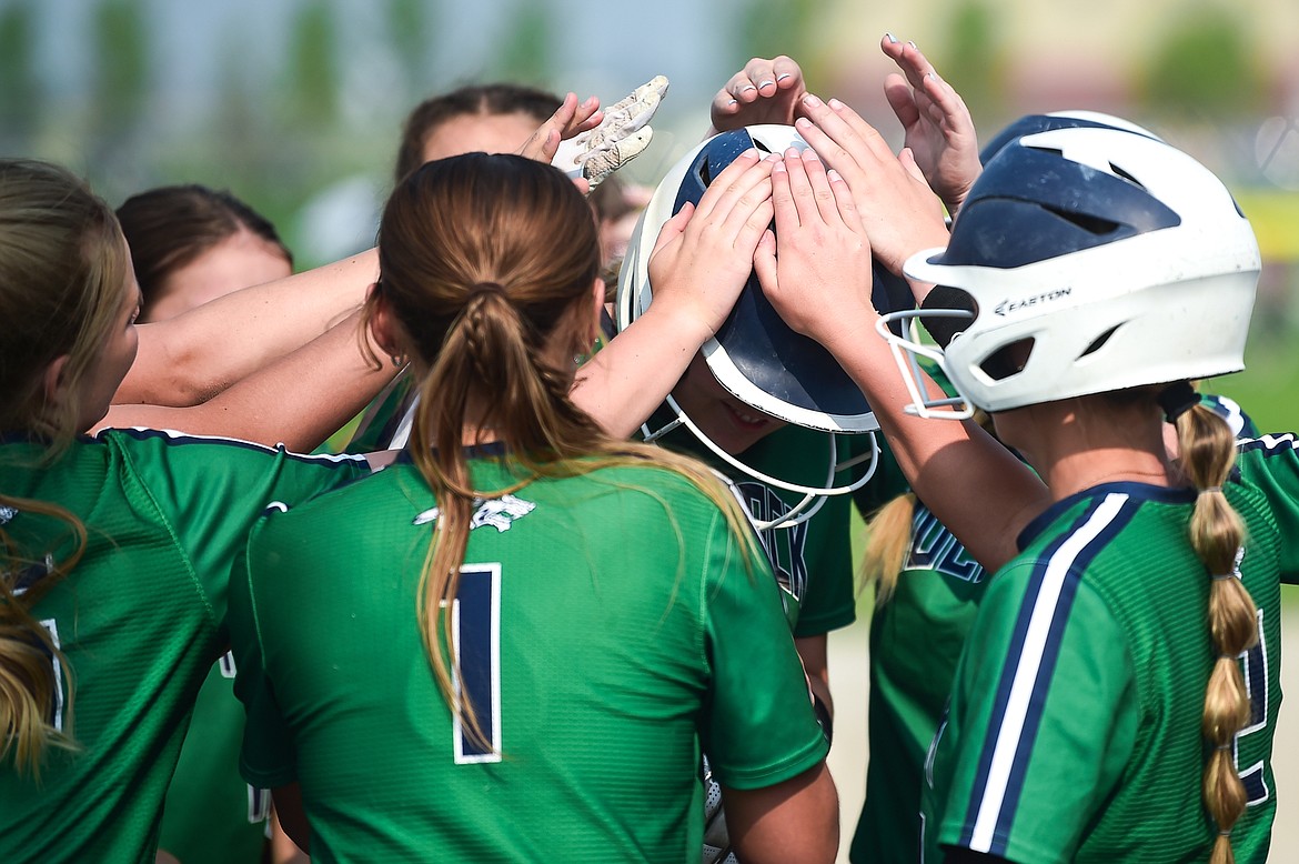 The Wolfpack celebrate with Emma Cooke (11) after Cooke's three-run home run in the first inning against Flathead at Glacier High School on Thursday, May 18. (Casey Kreider/Daily Inter Lake)