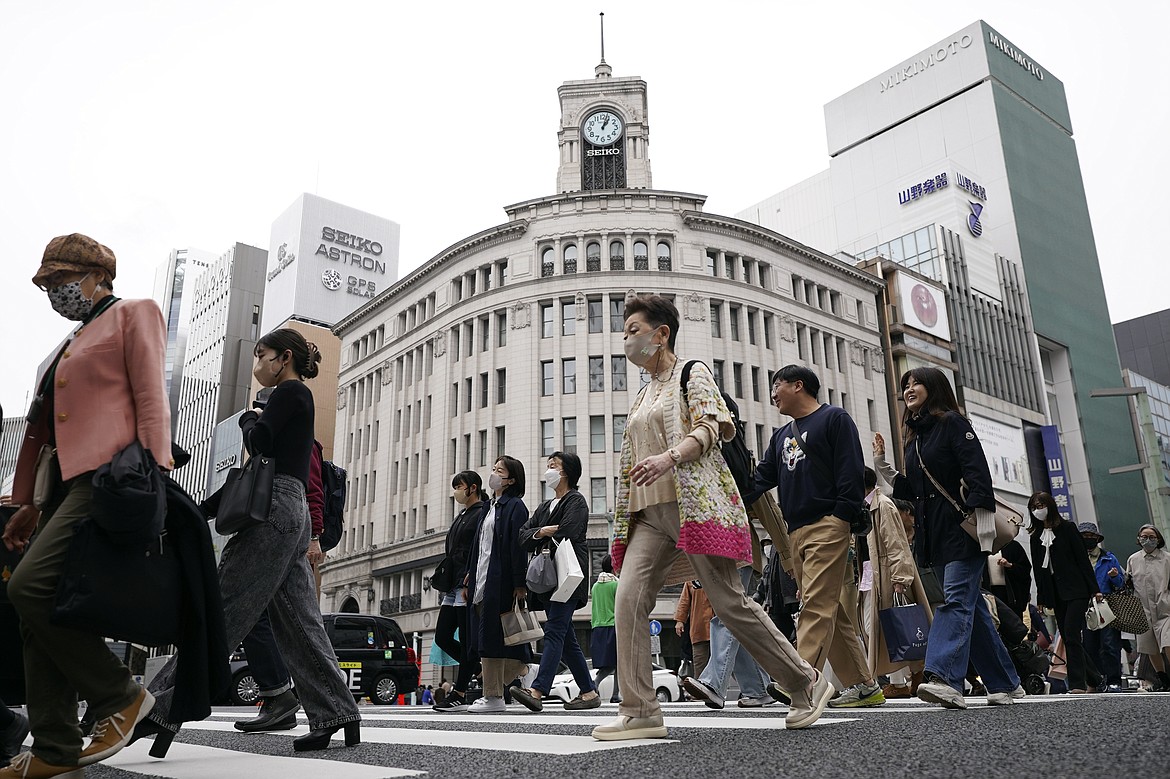 FILE - People walk at a pedestrian crossing in Ginza shopping district Friday, March 31, 2023, in Tokyo. Japan’s economy grew at an annual pace of 1.6% in the quarter through March as private demand rebounded after COVID-19-related restrictions were eased, according to data released Wednesday, May 17, 2023.(AP Photo/Eugene Hoshiko, File)