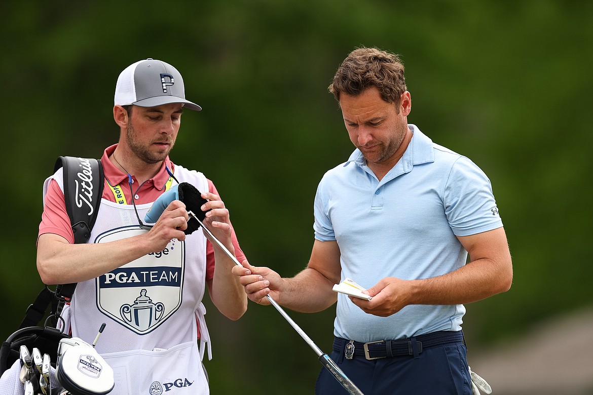 SCOTT TAETSCH/PGA of America
North Idaho College men's and women's golf coach and Coeur d'Alene High alum Russell Grove hands his putter to his caddie, former Viking teammate Taylor Pierce, during the second round of the PGA Championship at Oak Hill Country Club on Friday in Pittsford, N.Y.