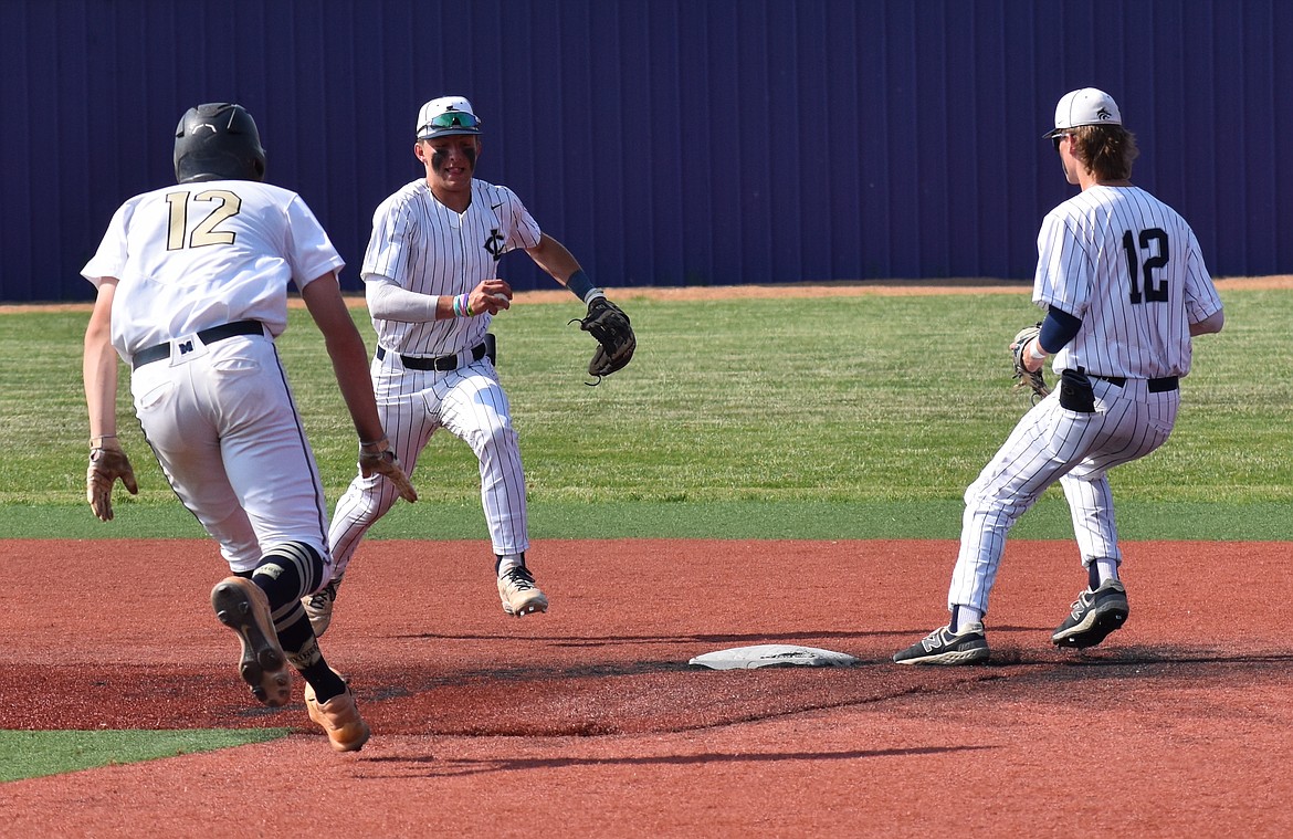 Photo by CANDICE SMITH
Lake City shortstop Joe DuCoeur heads to second base with the ball to start double play to end the sixth inning vs. Middleton in the semifinals of the state 5A baseball tournament Friday in Caldwell. At left is Micah Mendiola Jr. (12) of Middleton, and at right is Lake City second baseman Jake Dannenberg.