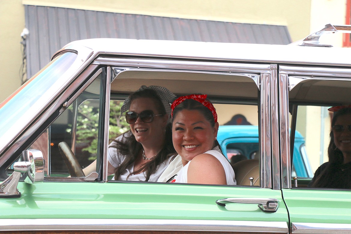 Lost of the '50s parade participants smile as they drive down First Avenue as hundreds of vintage and classic cars trekked through the downtown Friday.