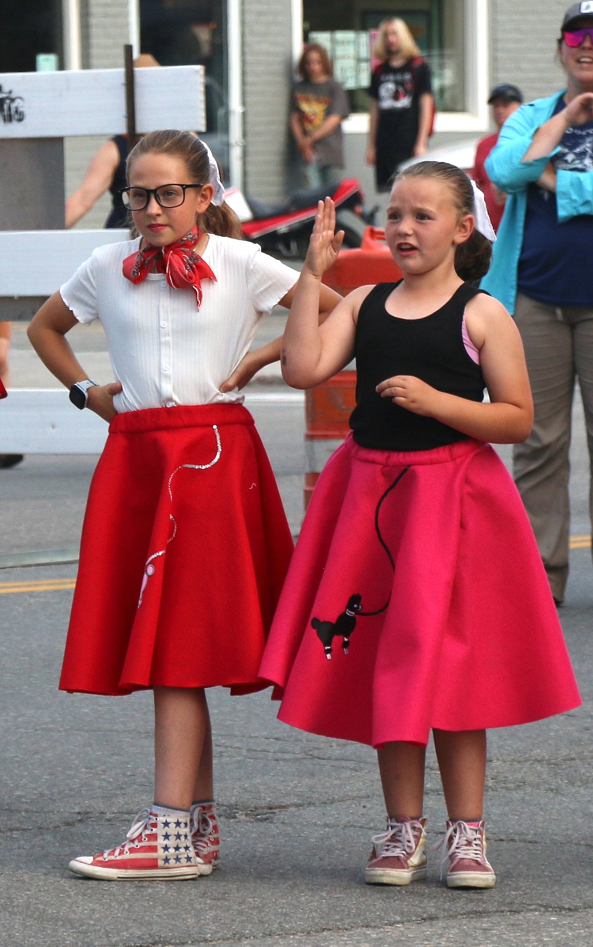 Lost in the '50s fans come dressed for the occasion as they wave to car parade participants on Friday night.